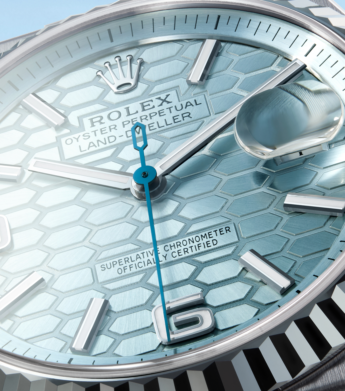 A close-up image of a brown leather watch strap with a silver clasp, showcasing a detailed metallic emblem and buckle mechanism, on a light blue background.